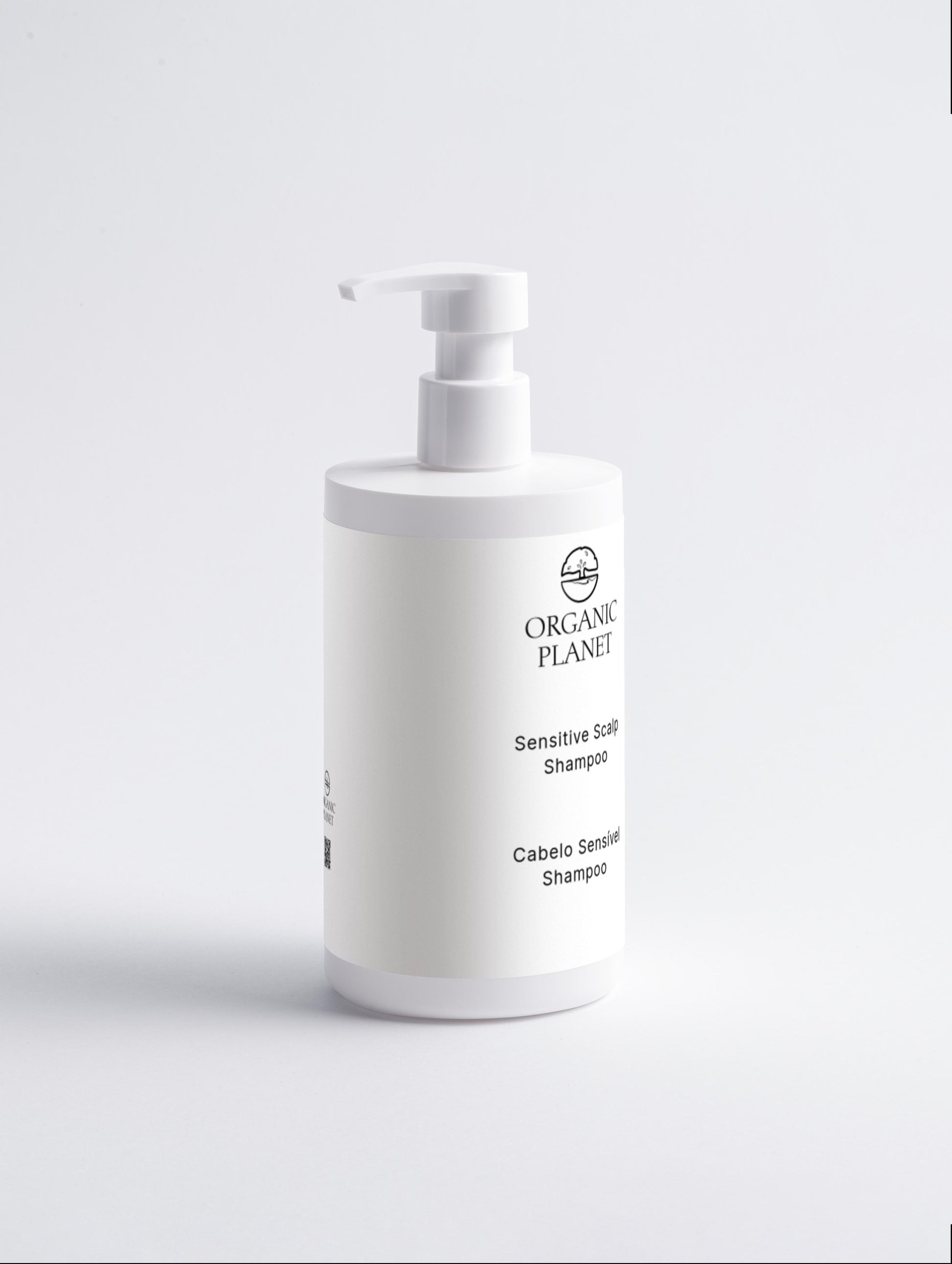 White shampoo bottle with pump labeled 'Organic Planet' on a light gray background