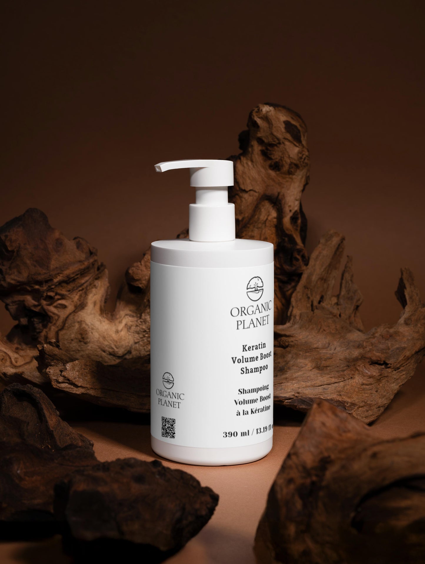 White bottle of Organic Planet shampoo on a brown background with natural elements. Keratin Volume Boost Shampoo