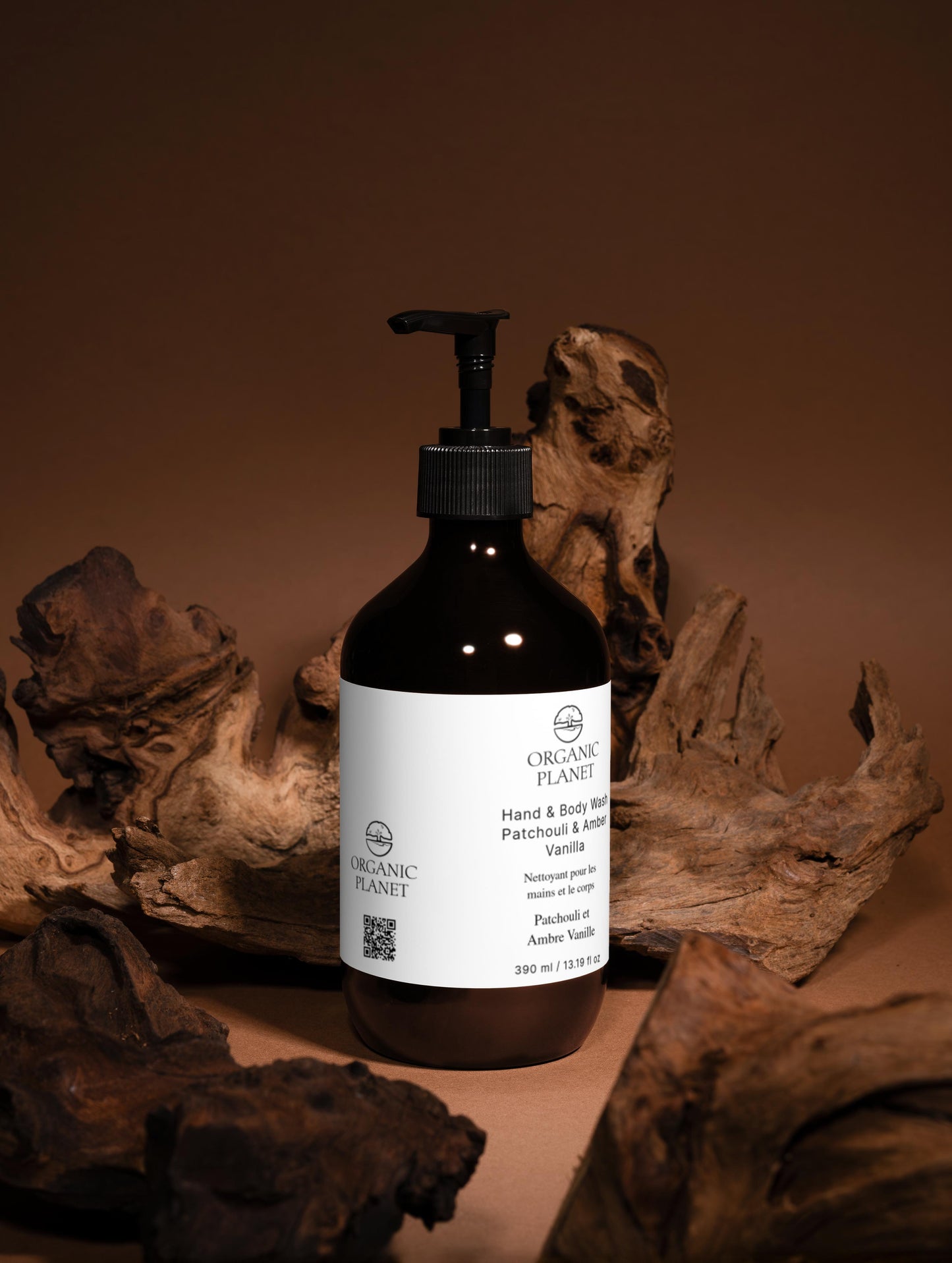 Pump bottle of ORGANIC PLANET Hand and Body Wash, Patchouli & Vanilla with a brown background.