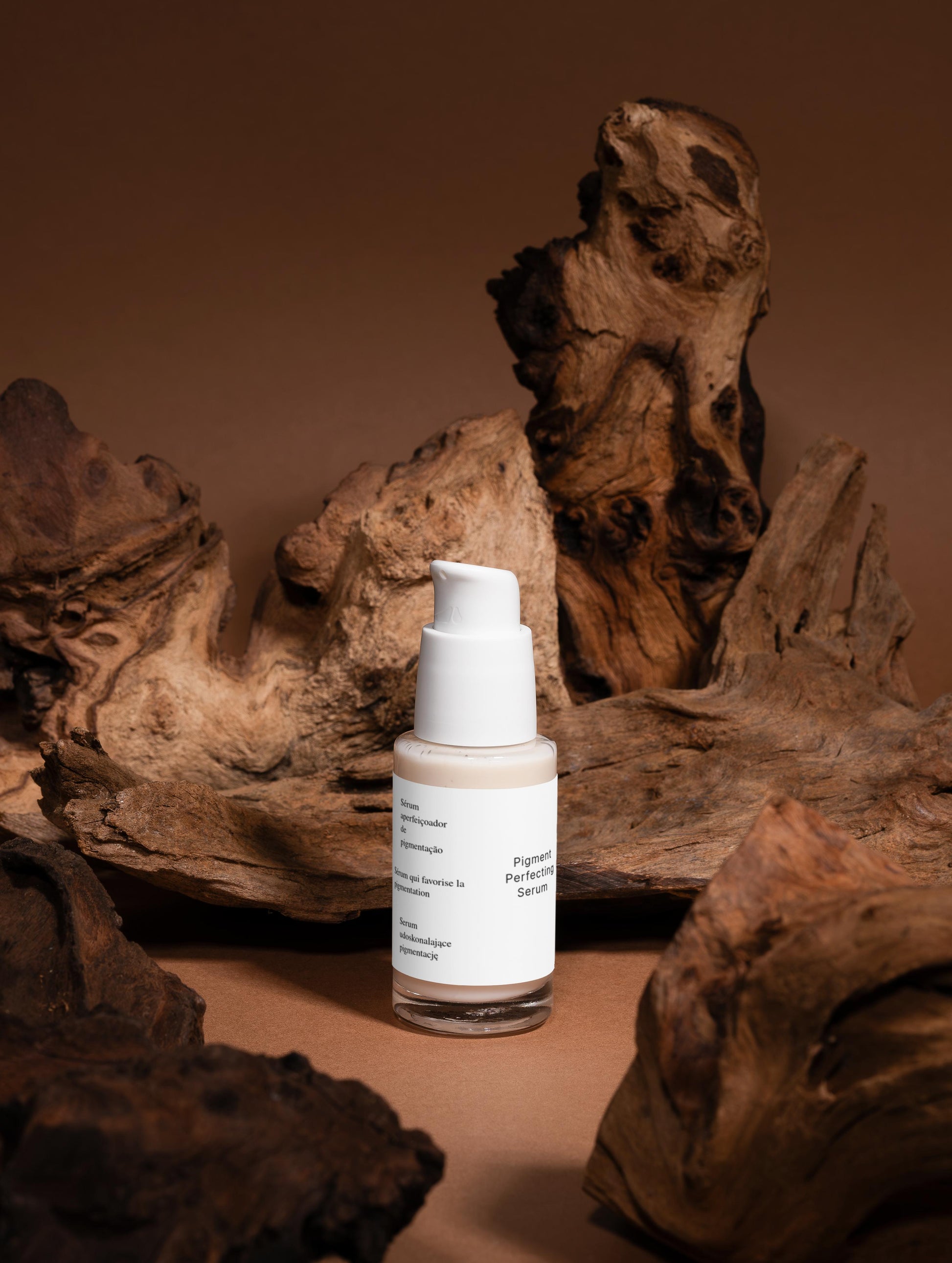 A targeted serum that reduces dark spots and evens skin tone for a brighter, more uniform complexion. The lightweight formula hydrates and soothes while tackling pigmentation concerns. Finished with an elegant blend of vetiver, wood, and almond notes. Skincare bottle with a label on a brown background with natural wood elements.